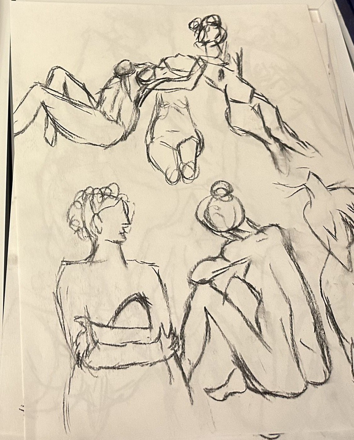 A sheet of five quick, loose charcoal sketches of crouching and reclining figures, drawn close together and overlapping.