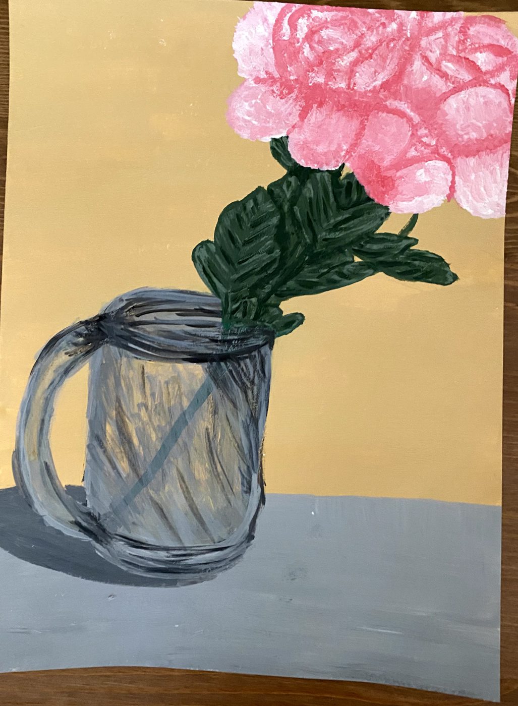 Painting of a pink flower with dark green leaves in a glass jar, set on a gray surface against a flat yellow-ochre wall.